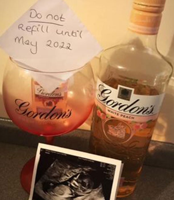 bottle of gin with a do not refill till May 2022 sign and an ultrasound pic