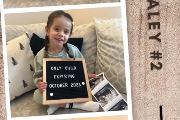 child holding up message board saying only child expiring October 2023