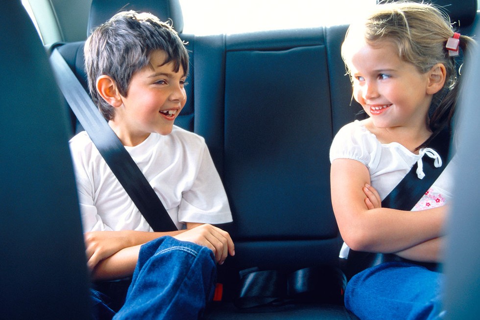 boy and girl in back seat of car looking happily at each other