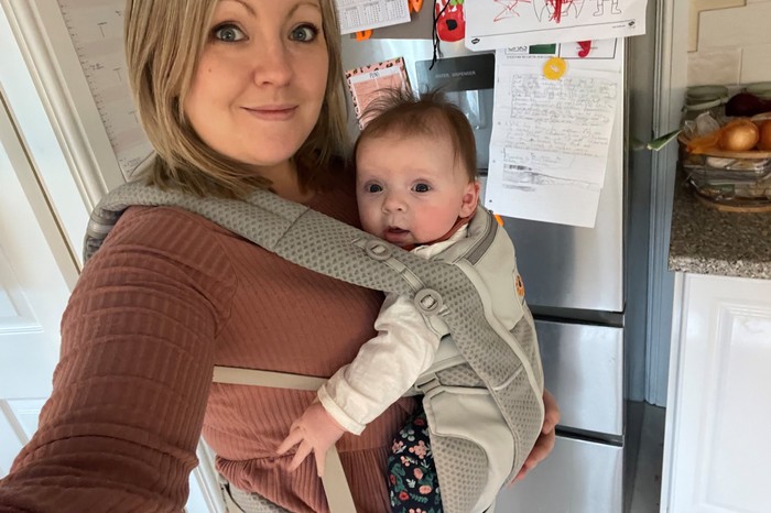 A mum holding her baby in the Ergobaby Omni Breeze Baby Carrier