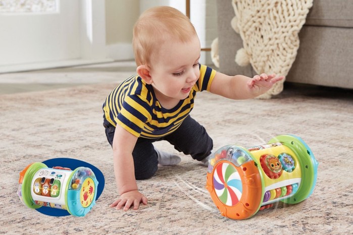 A baby crawling and using the Explore & Discover Roller